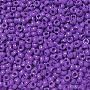 May include: A large quantity of small, round, purple plastic beads. The beads have a hole in the center for stringing.