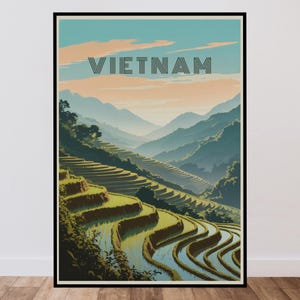 Op de afbeelding: Een ingelijste reisposter met een landschap van rijstterrassen in Vietnam. De illustratie toont groene heuvels, met water gevulde velden en verre bergen onder een bleke lucht. Het woord VIETNAM is gedrukt in dikke, donkere letters.