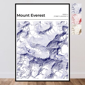 Op de afbeelding: Een ingelijste wandkunstprint met een blauwe topografische hoogtelijnenkaart van de Mount Everest op een witte achtergrond. De tekst luidt Mount Everest, 8.849 m, en 27,9881 N, 86,9250 E. Drie kleinere kleurvariaties staan in de rechterbovenhoek.