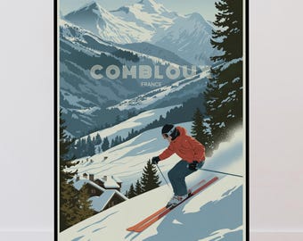 May include: A framed travel poster featuring a skier in an orange jacket and dark pants skiing down a snowy mountain slope. The background shows snow-covered peaks, pine trees, and chalets. The text COMBLOUX FRANCE is centered in the upper portion.