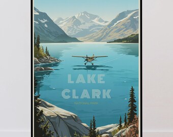 May include: A framed travel poster featuring a light blue lake surrounded by snow-capped mountains and evergreen trees. A small yellow floatplane is landing on the water. The text LAKE CLARK NATIONAL PARK is printed in white in the center.