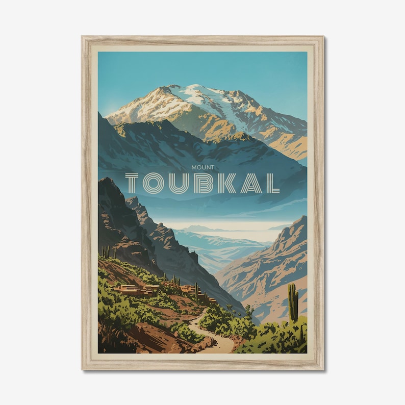 Peut inclure: Une impression d'art encadr&eacute;e repr&eacute;sentant une illustration stylis&eacute;e du mont Toubkal avec des sommets enneig&eacute;s, des pentes montagneuses bleu fonc&eacute; et un sentier sinueux &agrave; travers la v&eacute;g&eacute;tation. Le texte MOUNT TOUBKAL est centr&eacute; en blanc.