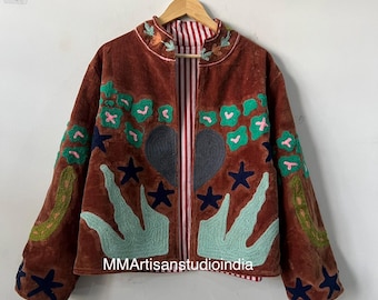Puede incluir: Chaqueta de terciopelo marrón con diseños bordados de flores y estrellas en verde, rosa y azul. La chaqueta tiene un forro a rayas y el texto "MMArtisanstudioindia".