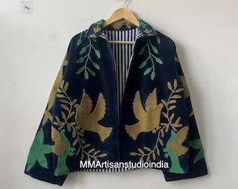 Op de afbeelding: Marineblauwe jas met goud- en groen geborduurde vogel- en bladmotieven. De jas heeft een gestreepte binnenkant en hangt aan een houten hanger. De tekst "MMArtisanstudioindia" is zichtbaar.