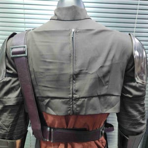 Pu&ograve; includere: Vista posteriore di un costume marrone con una cerniera sul retro. Il costume ha spalline marroni e spalline argentate.