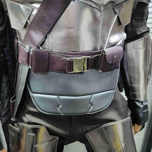 Pu&ograve; includere: Un costume in pelle argentata e marrone con cintura e fibbia. Il costume ha una finitura testurizzata, metallica e un pezzo toracico imbottito.
