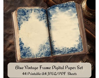 May include: An open book with aged pages featuring blue floral frame designs. The text "Blue Vintage Frame Digital Paper Set" is displayed on a white oval. The book is on a brown leather surface, with other books and a decorative object in the background.