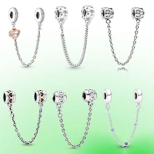 Può includere: Una collezione di catene di sicurezza per charm in argento con varie perline decorative. I disegni includono cuori, stelle e motivi floreali. Ogni catena ha una chiusura su entrambe le estremità.