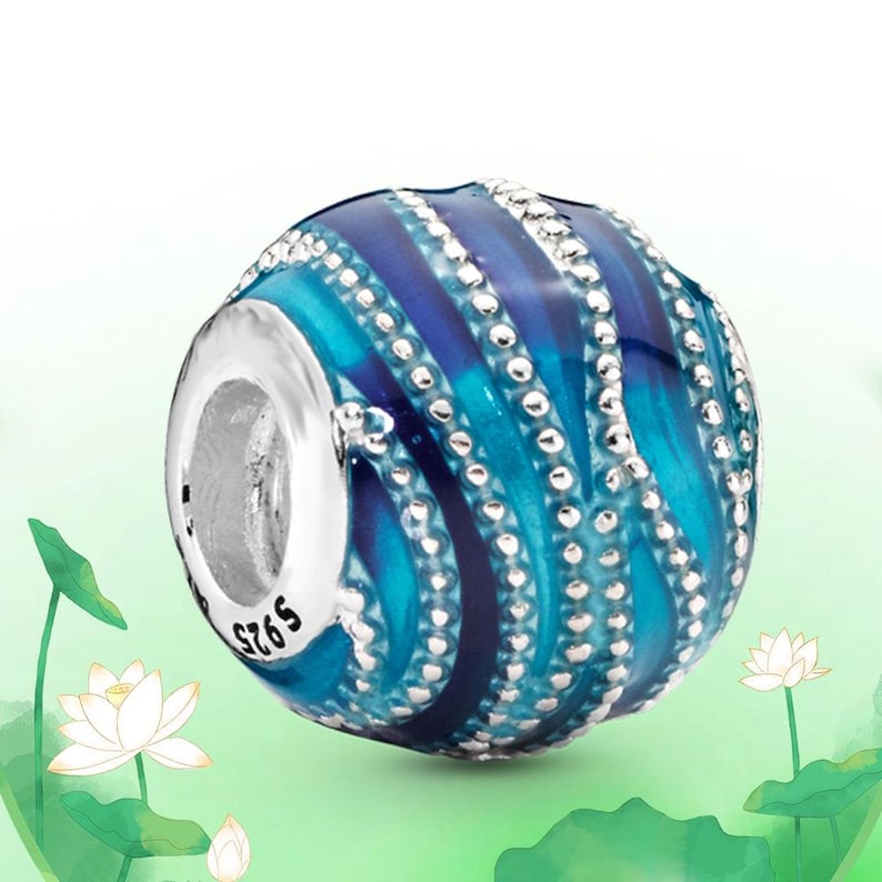 May include: A round bead with a silver-colored core and a blue and turquoise design. The bead has a striped pattern with small, silver-colored dots. The bead is marked with "S925".