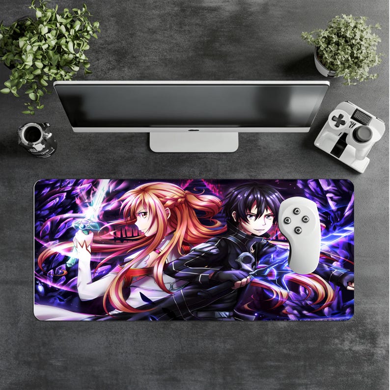 Puede incluir: Alfombrilla de rat&oacute;n rectangular con personajes de anime sobre un fondo morado y negro. Un mando blanco est&aacute; encima. La imagen tambi&eacute;n muestra un monitor de ordenador, una peque&ntilde;a planta y un mando de juego blanco.