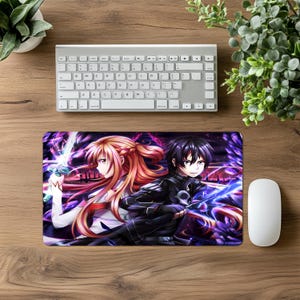 Puede incluir: Alfombrilla de rat&oacute;n rectangular con una vibrante ilustraci&oacute;n de anime de dos personajes con espadas, sobre un fondo morado y azul. La imagen est&aacute; junto a un rat&oacute;n blanco, un teclado y vegetaci&oacute;n sobre una superficie de madera.
