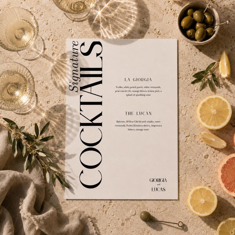Op de afbeelding: Een cocktailmenu met de woorden "Signature Cocktails" in grote zwarte letters. Het menu bevat twee cocktails, "La Giorgia" en "The Lucan", met ingredi&euml;nten. Garneringen zijn olijven, citroenen en grapefruit. Twee champagneglazen zijn zichtbaar.
