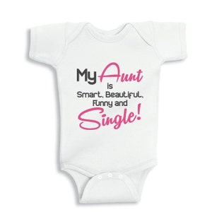 Puede incluir: Un body blanco para bebé con texto negro y rosa que dice "My Aunt is Smart, Beautiful, Funny and Single!"