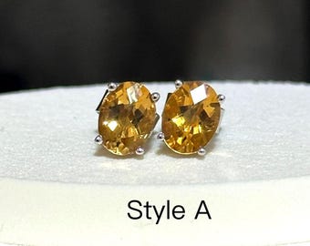 Puede incluir: Un par de pendientes de botón con piedras preciosas de color amarillo dorado y corte ovalado. Las piedras están engastadas en un metal plateado con cuatro garras. El texto "Style A" está impreso debajo.
