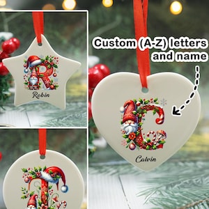 Könnte beinhalten: Personalisierbare Weihnachtsschmuck in Stern-, Herz- und runder Form. Jeder Schmuck zeigt einen Buchstaben, einen Zwerg und einen Namen. Die Dekorationen sind mit festlichen Elementen und einem roten Band zum Aufhängen verziert. Der Text auf dem Bild lautet "Custom (A-Z) letters and name."