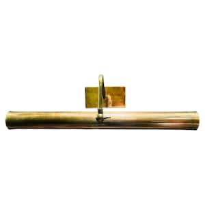 Op de afbeelding: Een messing schilderijlamp met een rechthoekige achterplaat en een gebogen arm. De lamp heeft een cilindrisch lichaam en een kleine schakelaar. Ontworpen om kunstwerken te verlichten.