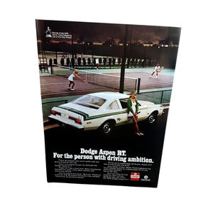 May include: Vintage advertisement for the 1976 Dodge Aspen RT. The image features a white car with green stripes, a tennis court, and two women playing tennis. The ad's text reads, "For the person with driving ambition."