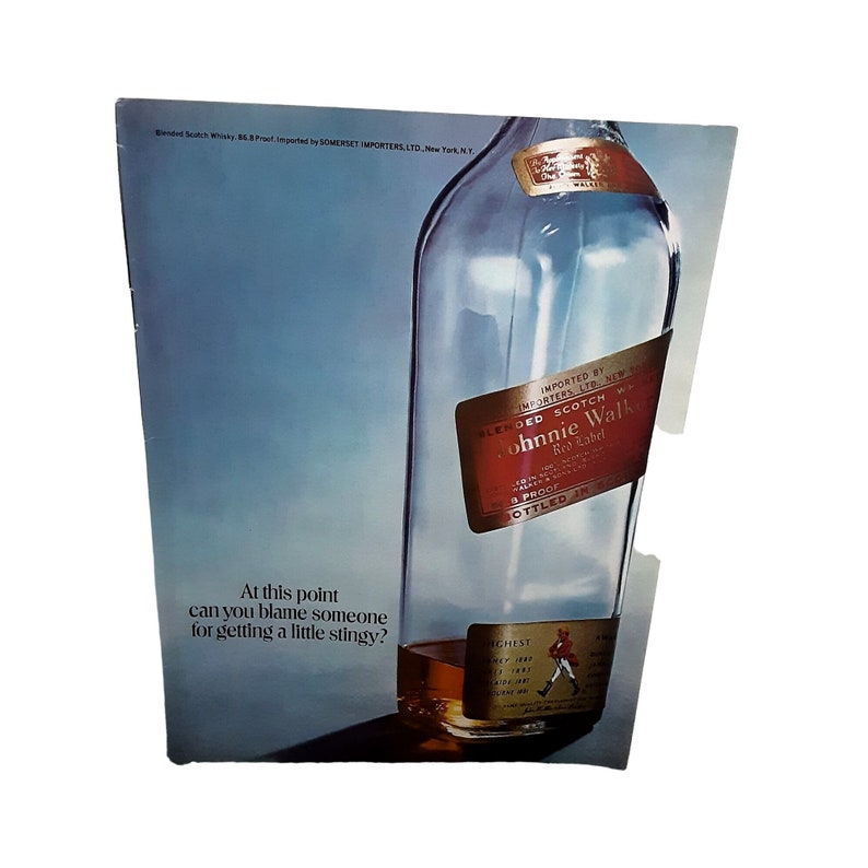 Pu&ograve; includere: Una bottiglia di vetro trasparente di whisky scozzese Johnnie Walker Red Label. La bottiglia &egrave; parzialmente oscurata da uno sfondo blu. L'etichetta &egrave; rossa e presenta il logo e il testo Johnnie Walker. Il testo sull'etichetta recita "Blended Scotch Whisky, 86.8 Proof, Imported by Somerset Importers Ltd., New York, N.Y.". Il testo "At this point can you blame someone for getting a little stingy?" &egrave; stampato sotto la bottiglia.