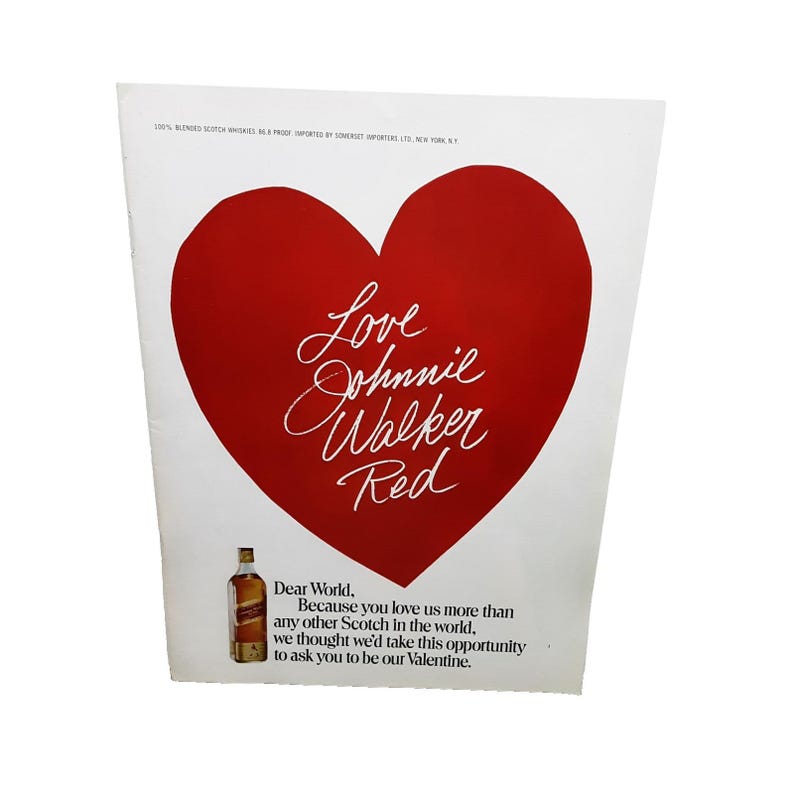 Puede incluir: Un anuncio vintage con un gran coraz&oacute;n rojo y el texto "Love Johnnie Walker Red". Una botella de Johnnie Walker Red est&aacute; en la parte inferior, con texto debajo. El anuncio est&aacute; sobre un fondo blanco. El texto dice "Querido mundo, porque nos amas..."