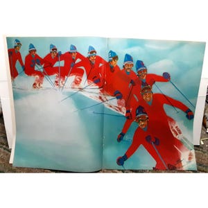 May include: A group of skiers in red and blue ski suits are skiing down a snowy slope. The skiers are all wearing blue hats and are holding ski poles. The skiers are all smiling and appear to be enjoying themselves.