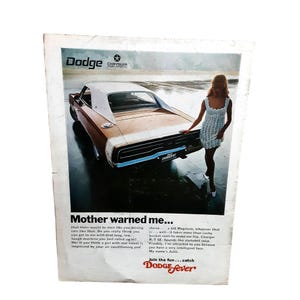 May include: A vintage print advertisement for a Dodge Charger R/T featuring a brown and white car on a wet surface. The text reads Mother warned me... and Join the fun... catch Dodge fever. A person in a white dress stands beside the vehicle.