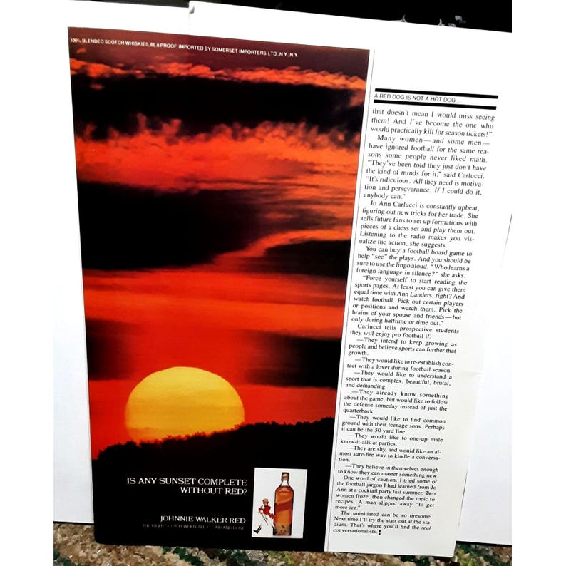 K&ouml;nnte beinhalten: Ein Sonnenuntergang mit rotem Himmel und einer gro&szlig;en, leuchtend orangen Sonne. Der Text "Is any sunset complete without red?" ist unter dem Bild gedruckt. Eine Flasche Johnnie Walker Red Scotch Whisky ist in der unteren rechten Ecke des Bildes zu sehen.