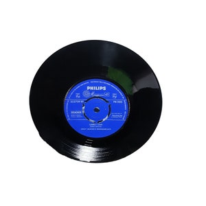 May include: A black vinyl record with a blue label. The label has the text "PHILIPS", "322709 BF", "BEM NO", "LONILY LOVE", "JERRY MURAD'S HARMONICATS", and "PB 1105".