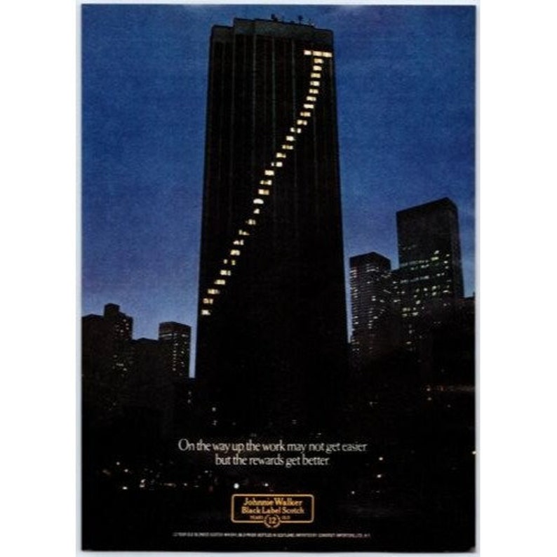 K&ouml;nnte beinhalten: Eine Schwarzwei&szlig;-Anzeige f&uuml;r Johnnie Walker Black Label Scotch. Die Anzeige zeigt einen hohen Wolkenkratzer mit einer Reihe beleuchteter Fenster und den Text "On the way up the work may not get easier but the rewards get better".