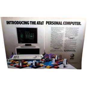 May include: An advertisement for the AT&T Personal Computer. The image features a computer monitor, keyboard, and a model cityscape. The text reads "INTRODUCING THE AT&T PERSONAL COMPUTER." and "AT&T INFORMATION SYSTEMS WHEN YOU'VE GOT TO BE RIGHT."