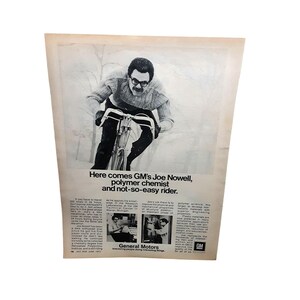 May include: Black and white advertisement featuring a man riding a bicycle. The text reads "Here comes GM's Joe Nowell, polymer chemist and not-so-easy rider." Additional text and images of a laboratory are also present.