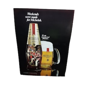 May include: An advertisement for Michelob beer. The image features a bottle and a glass of beer, both with the Michelob logo. The text reads "Weekends were made for Michelob" and "It's an unexpected pleasure."