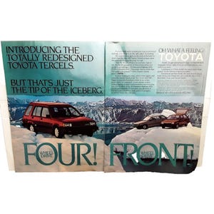 May include: A vintage print advertisement for the Toyota Tercel, featuring a red Toyota Tercel wagon on a snowy mountain background. The ad highlights the car's four-wheel drive and front-wheel drive options, with the text "Four! Front!" in large, bold letters.