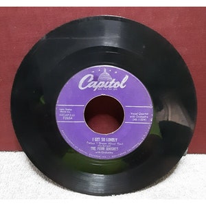 May include: A purple vinyl record with the Capitol Records label. The record features the song "I Get So Lonely (When I Dream About You)" by The Four Knights with Orchestra. The record number is F2654.