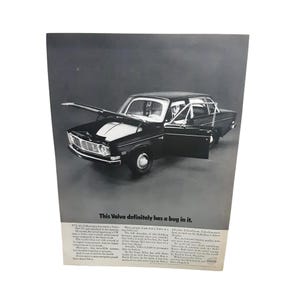May include: Black and white advertisement featuring a vintage Volvo sedan with the hood and door open. The text "This Volvo definitely has a bug in it." is displayed at the top. The advertisement includes additional text.