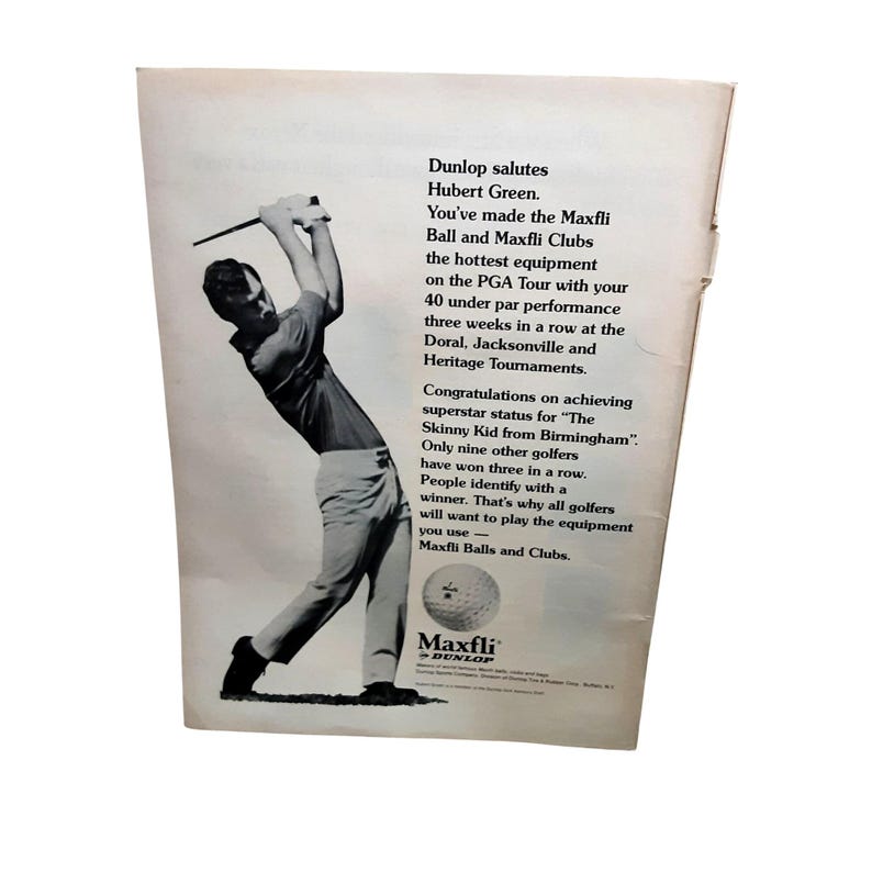 May include: Vintage advertisement featuring a golfer mid-swing. The ad, in black and white, promotes Maxfli golf balls and clubs, highlighting Hubert Green's achievements on the PGA Tour. Text includes "Maxfli Balls and Clubs" and "Dunlop salutes Hubert Green."