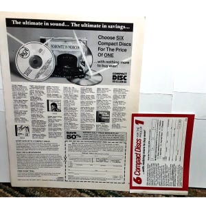 May include: A black and white advertisement for a compact disc club. The ad features a photo of a compact disc with the RCA logo and the text "HOROWITZ IN MOSCOW". The ad also includes text that says "Choose SIX Compact Discs For The Price Of ONE...with nothing more to buy ever!" and "SAVE 50%".
