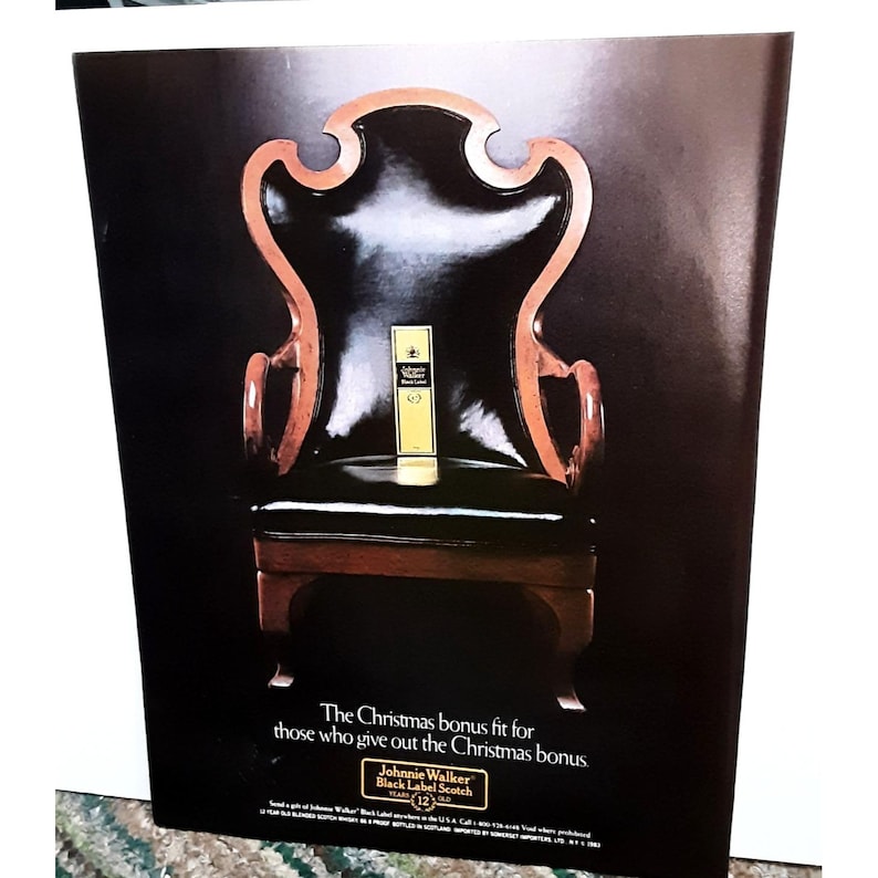 Pu&ograve; includere: Una pubblicit&agrave; vintage per il whisky Johnnie Walker Black Label Scotch. La pubblicit&agrave; presenta una poltrona in pelle nera con una bottiglia di whisky Johnnie Walker Black Label Scotch seduta sul sedile. Il testo recita "Il bonus natalizio adatto a coloro che distribuiscono il bonus natalizio."