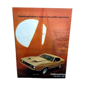 May include: An advertisement for a gold-colored Ford Mustang Mach 1. The ad features the car on a brown background with a large white circle and text that reads "Control and balance make it a beautiful experience."