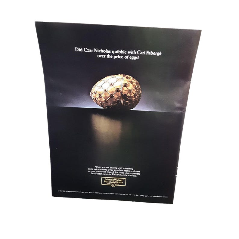 K&ouml;nnte beinhalten: Eine Vintage-Werbung f&uuml;r Johnnie Walker Black Label Scotch Whisky mit einem goldenen Faberg&eacute;-Ei und dem Text "Hat Zar Nikolaus mit Carl Faberg&eacute; &uuml;ber den Preis von Eiern gestritten?"  Wenn man mit etwas ganz Besonderem zu tun hat, scheint der Preis pl&ouml;tzlich irrelevant.  Johnnie Walker Black Label Scotch.