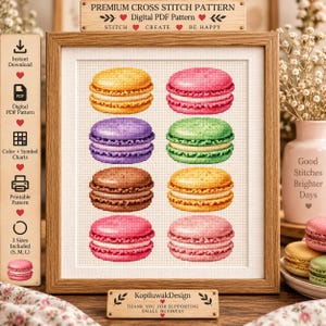 May include: A framed cross stitch pattern featuring eight colorful macarons in yellow, pink, purple, green, brown, orange, and light pink. The text reads PREMIUM CROSS STITCH PATTERN, DIGITAL PDF PATTERN, STITCH CREATE BE HAPPY, and KopiluwakDesign.