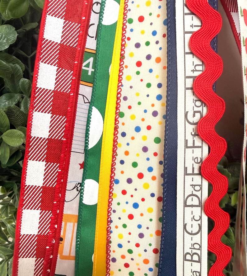 May include: A collection of vertical fabric ribbons featuring various patterns including red and white gingham, green with white polka dots, a solid yellow strip, a cream ribbon with multicolored dots, a navy blue edge, and a red rickrack trim.
