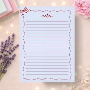 May include: A light blue notepad with a red wavy border and the word "notes" in cursive. The notepad has horizontal lines for writing and a small bow design in the upper left corner.