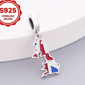 Peut inclure: Un charm en argent sterling en forme de carte de Grande-Bretagne, avec des détails en émail rouge, blanc et bleu. Le bijou comprend une bélière circulaire pour la fixation et porte l'inscription S925 STERLING SILVER dans un sceau rouge.
