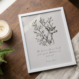 Könnte beinhalten: Weiß gerahmter Kunstdruck mit einer schwarz-weißen Illustration eines Hirsches mit floralen Akzenten. Der Druck enthält den Text "The Lord is with me: I will not be afraid. What can man do to me? Psalm 118:6."