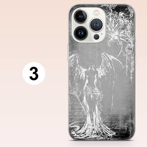 May include: A smartphone case featuring a monochromatic gray and white design. The graphic depicts a winged figure standing in a long gown, surrounded by intricate floral patterns and faint, cursive script text layered across the background.