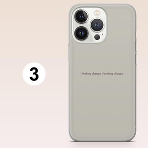 May include: A light gray phone case with a quote that reads, "Nothing changes if nothing changes." The case has a clear border and a camera cutout. A white circle with the number "3" is on the left.