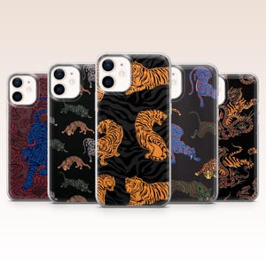 May include: A collection of phone cases with various tiger designs. The cases feature different patterns, including orange tigers on black zebra stripes, blue tigers on a dark background, and other tiger illustrations.