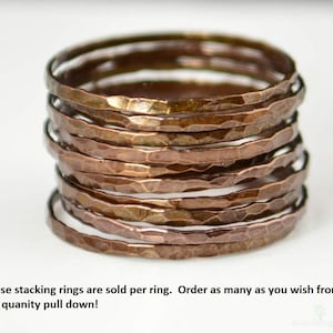 May include: A stack of hammered copper stacking rings. The rings have a textured surface and a warm, metallic color. The rings are sold individually. Order as many as you wish.