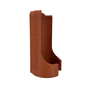 May include: A brown, molded plastic holster with a curved base and a rectangular opening. The holster has a textured, zig-zag pattern on the side. The design is a simple, functional shape.
