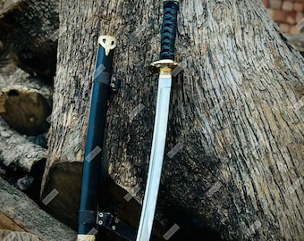 May include: A katana sword with a silver blade and black handle, next to its black sheath. The handle is wrapped in a black cord. Gold-coloured accents are visible on the sword and sheath.